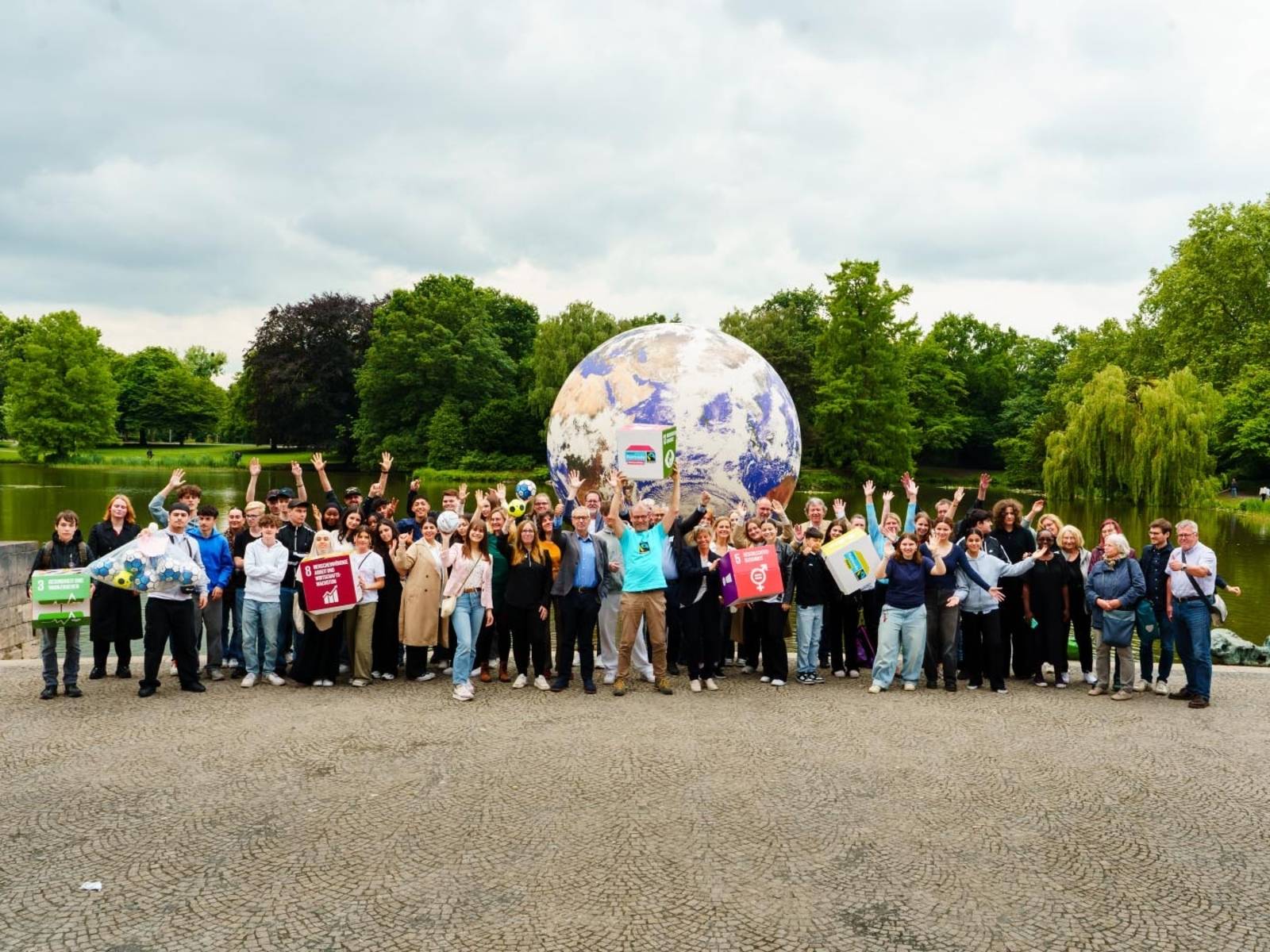 Schülerinnen und Schüler bei einer Verleihung. Sie stehen ganz vorne. Im Hintergrund ein projiziertes Foto aus der Schule.