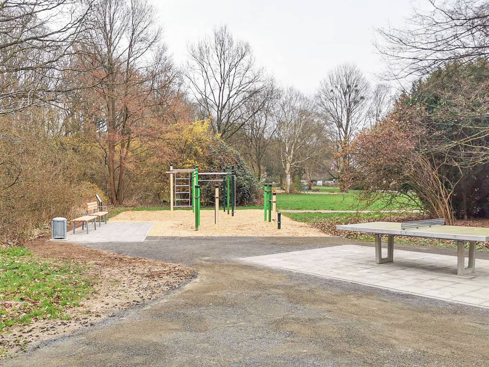 Ein Fitnessparcours im Grünen. Rechts davon eine Tischtennisplatte.