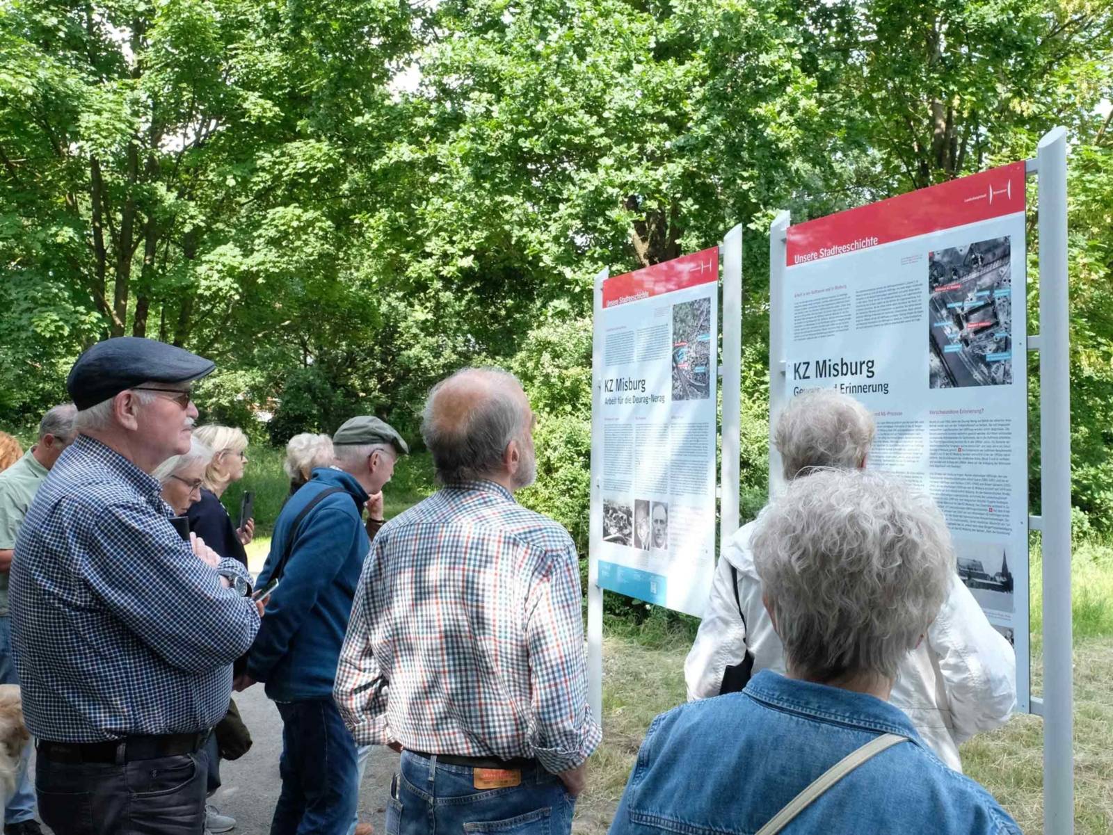 Interessierte beim Lesen der Informationstafel zur Geschichte des KZ Misburg