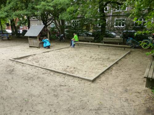 Ein Sandkasten auf einem Spielplatz.