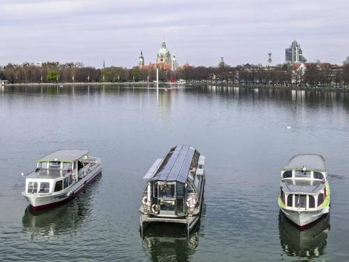 Drei Boote auf dem Maschsee, im Hintergrund Rathaus.