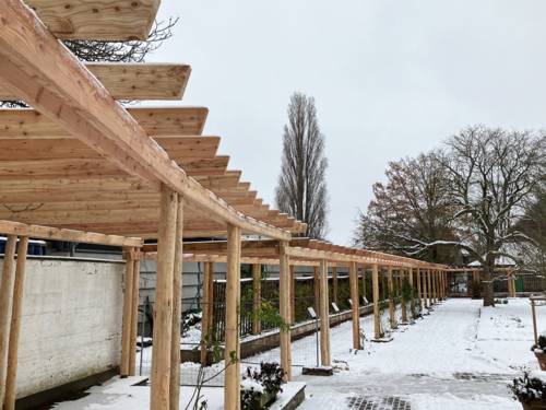 Eine Pergola in einem verschneiten Park.