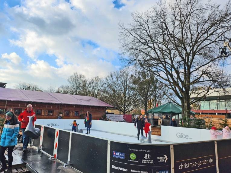 Kinder auf einer künstlichen Eislaufbahn.