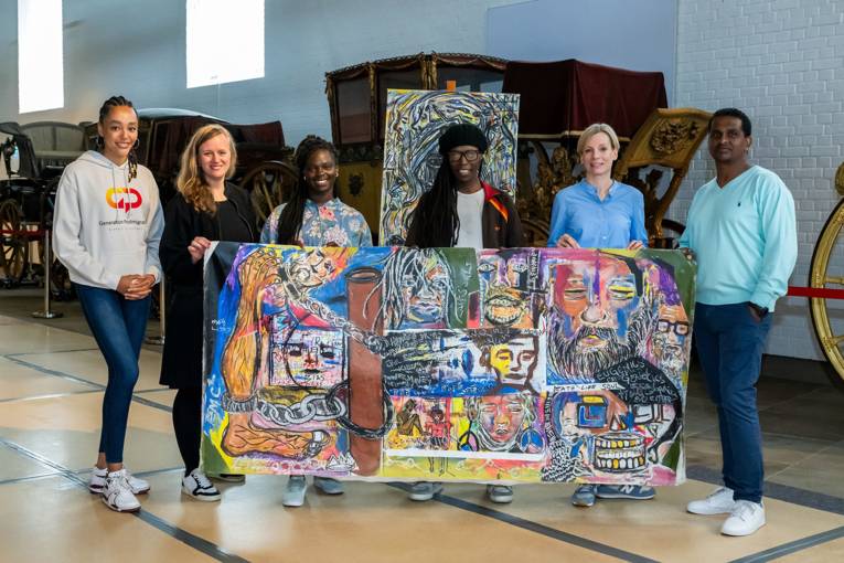 Bildübergabe nach Ankauf zweier Gemälde in der Kutschenhalle des HMH, 04.06.2024
von rechts nach links: Daniel Kalifa (Leitung Antidiskriminierungsstelle der Landeshauptstadt Hannover), Katharina Rünger Museen für Kulturgeschichte, James Audi (Künstler, aka MohzArt), Brenda Davina (wissenschaftliche Koordinatorin Koloniales Erbe Stadt Hannover), Anne Gemeinhardt Museen für Kulturgeschichte,  Innawa Bouba (Vorsitzende Generation Postmigration e.V.)