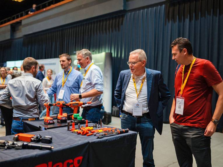 Menschen vor einem Messestand mit Werkzeugen