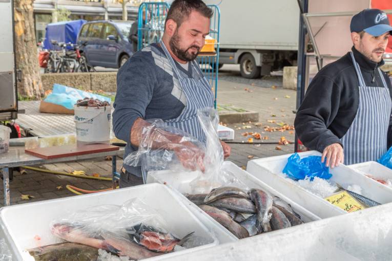 Zwei Fischverkäufer an einem Marktstand.