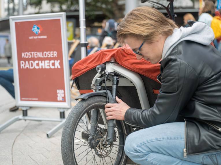 Ein Mann kniet vor einem Fahrrad und überprüft die Radgabel.