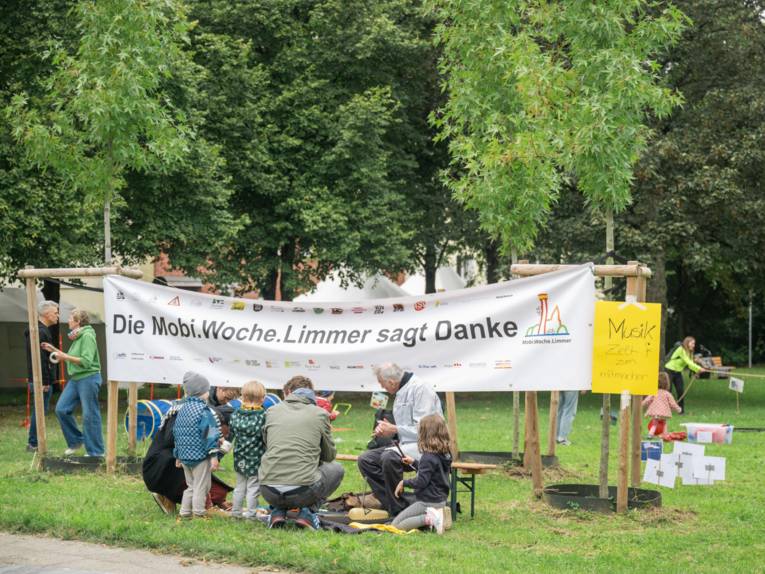 Eine Gruppe von Menschen sitzt vor einem Banner auf dem folgender Text steht: "Die Mobi.Woche.Limmer sagt Danke"